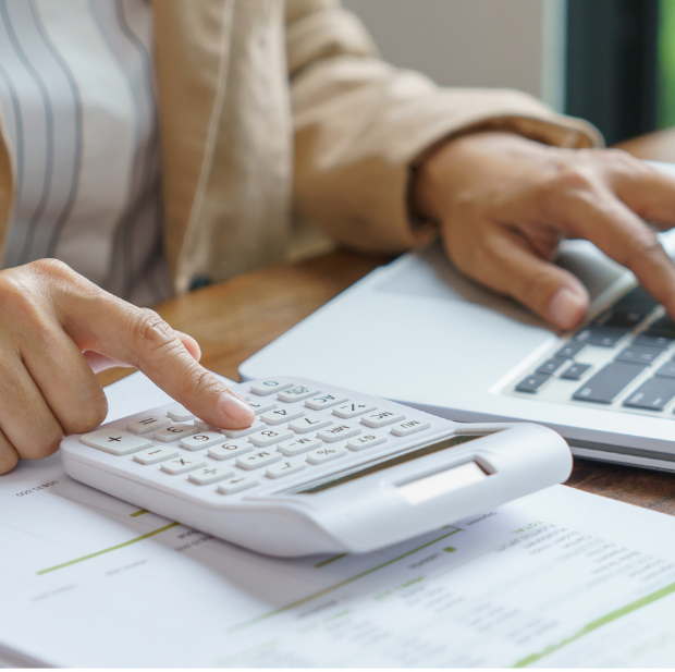 Person using calculator and laptop for life care planning and cost assessment